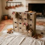 Calendrier de l'Avent en bois avec tiroirs gourmands remplis de chocolats et épices sur une table de ferme rustique