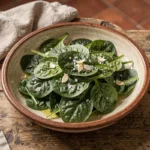 Épinards frais dans un plat en céramique prêts à cuire au four avec huile d'olive et ail